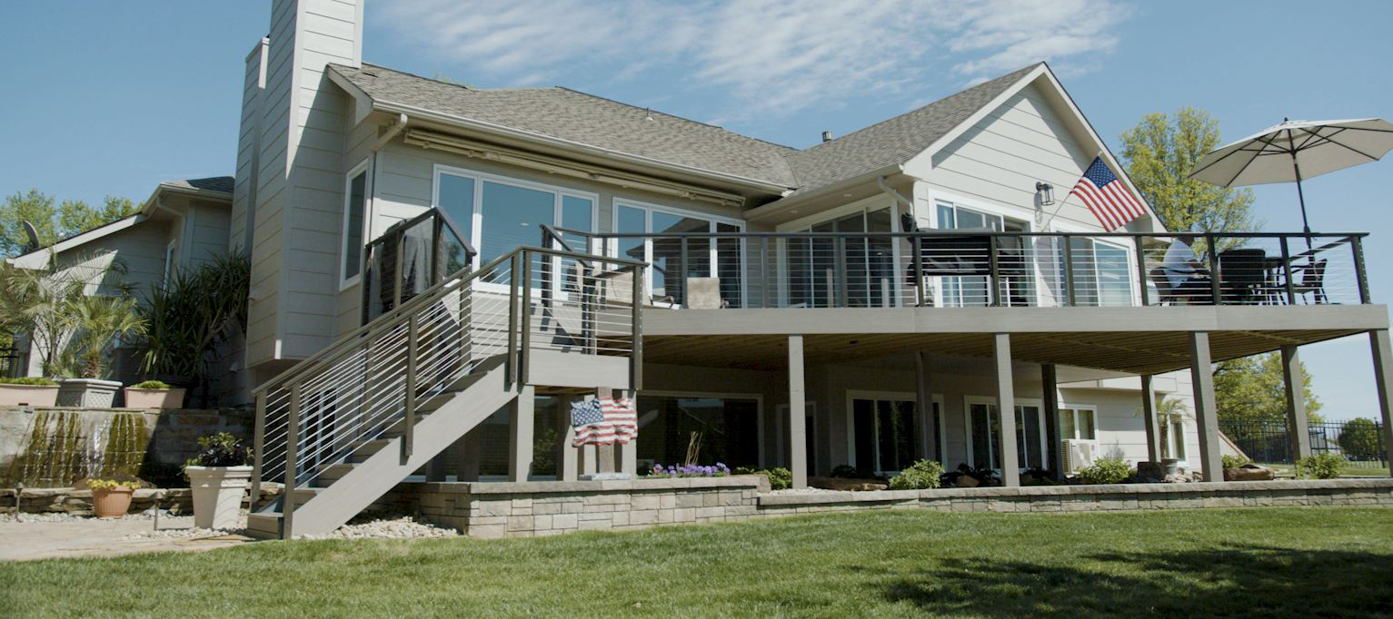 Grey house backyard with two story deck